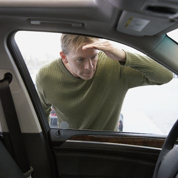 Interior shot of car looking out at man looking in window