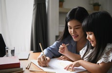 Mother working from home coloring with young daughter