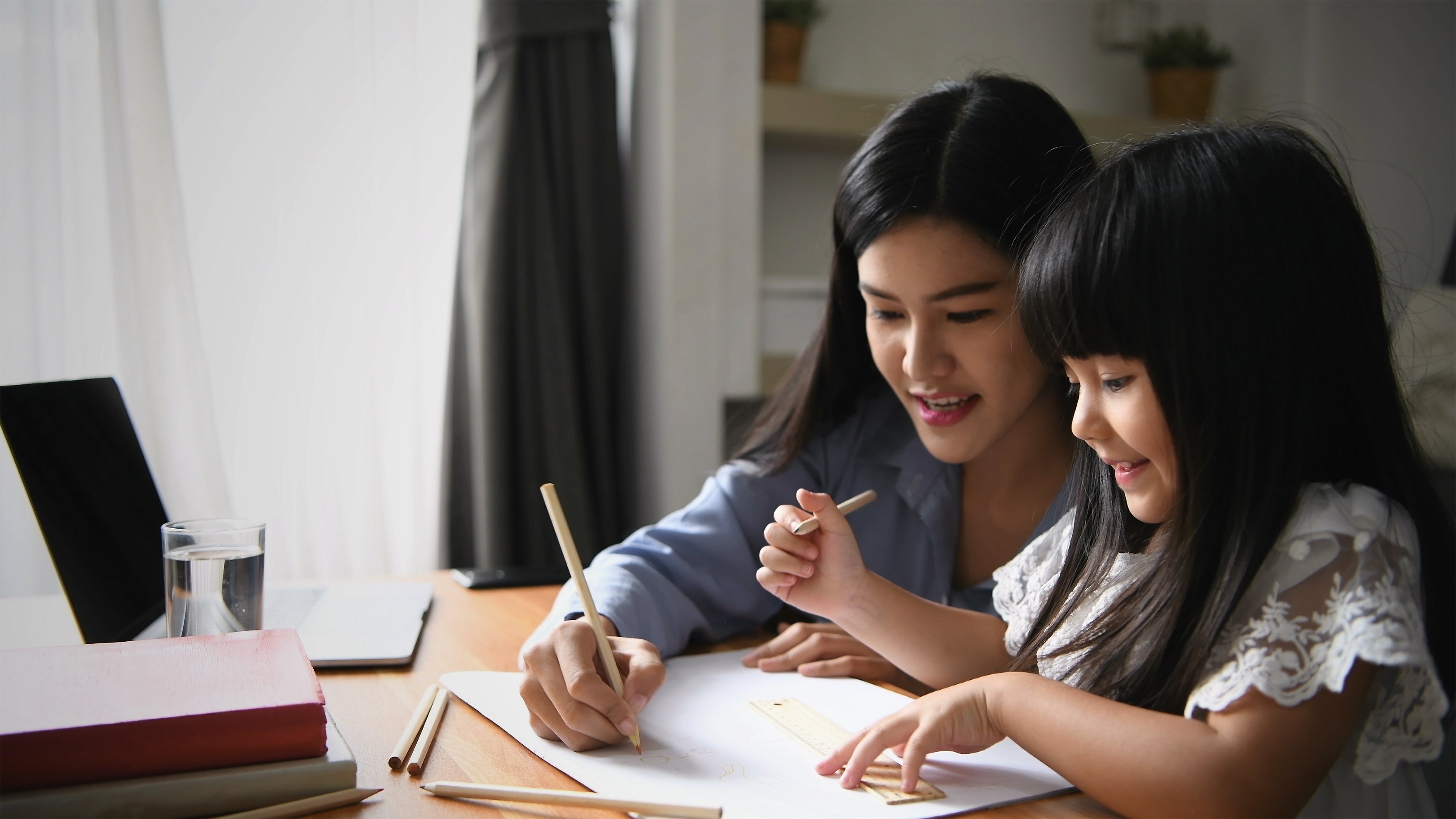 Mother working from home coloring with young daughter