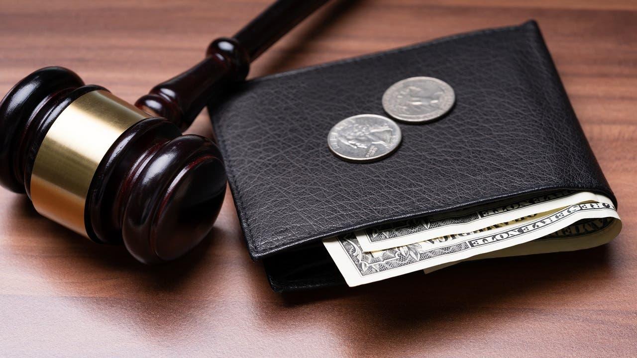 Wallet with money sitting next to judge gavel