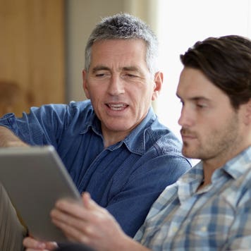 Father and son look at tablet