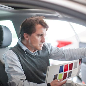Man sitting in car looking at color samples