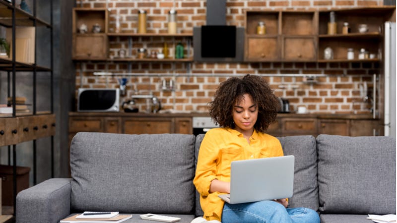 Young woman works on laptop from home