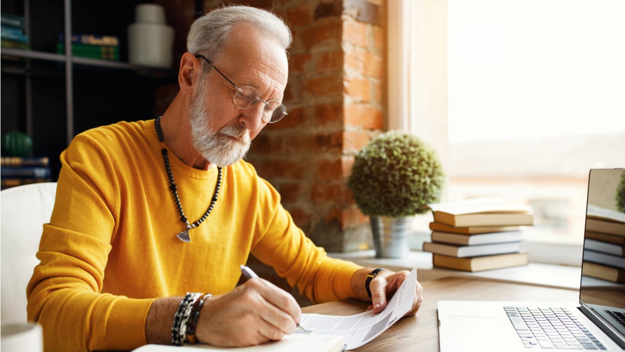 Man makes notes on a financial document