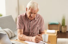 Elderly man works on finances