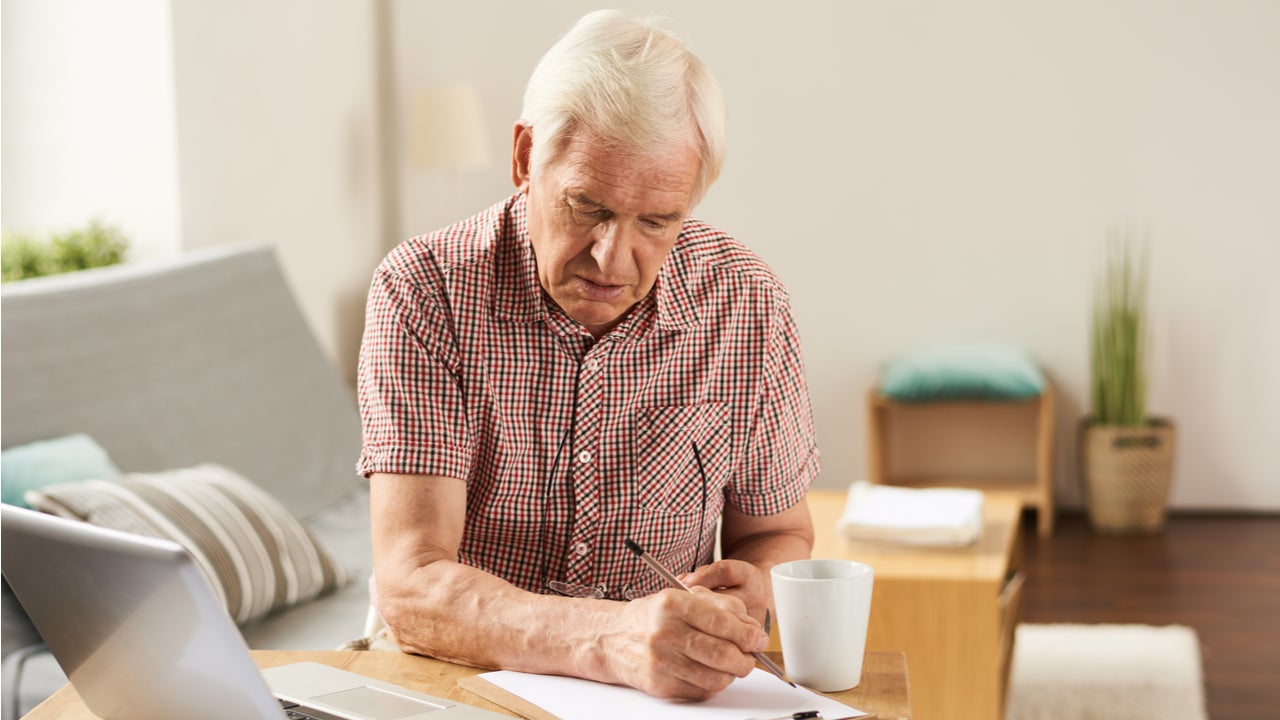 Elderly man works on finances