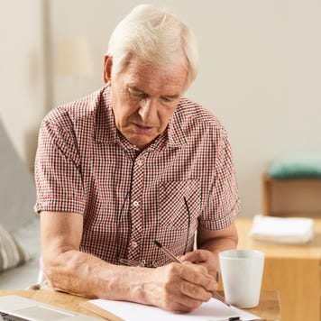Elderly man works on finances