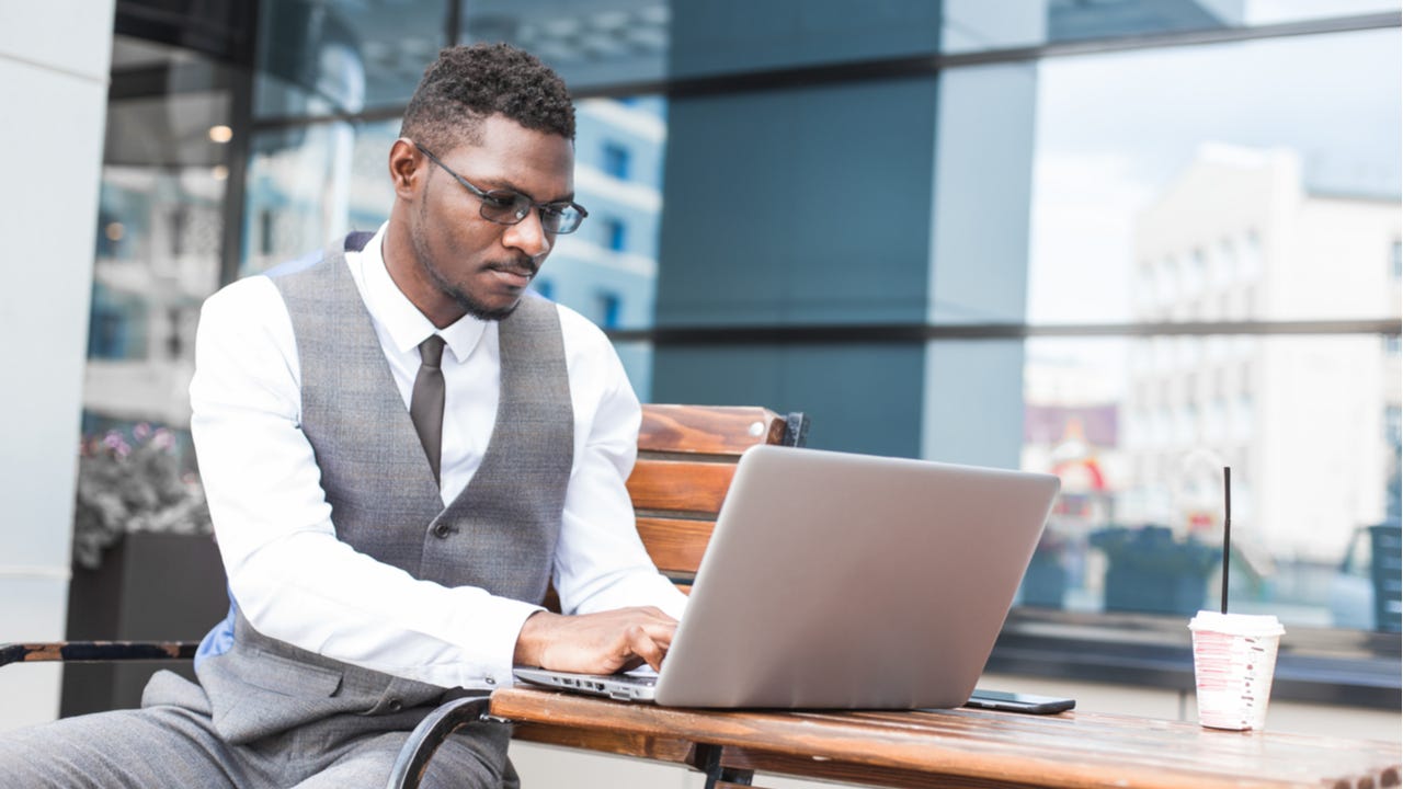 Man works on investing on laptop