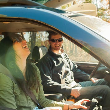 Woman and man in car, both laughing