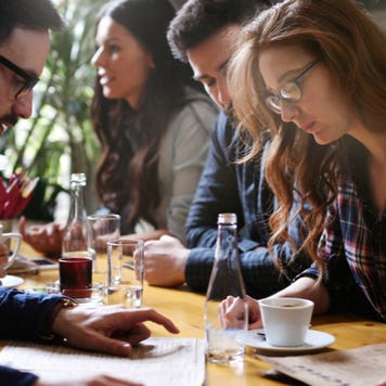 Young people looking at menu in restaurant