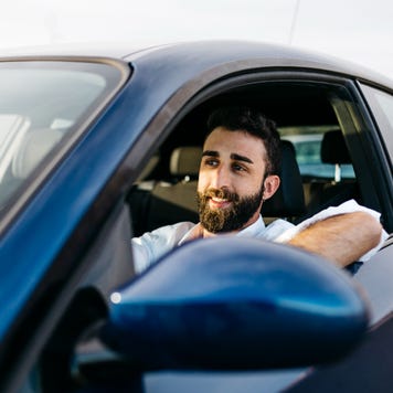 A man drives a blue car.