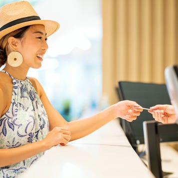 Woman paying for hotel room with credit card while on vacation.