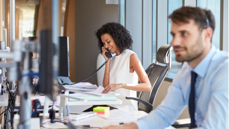 jonge vrouw die aan de telefoon werkt