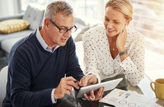 Couple using a digital tablet while going through paperwork at home