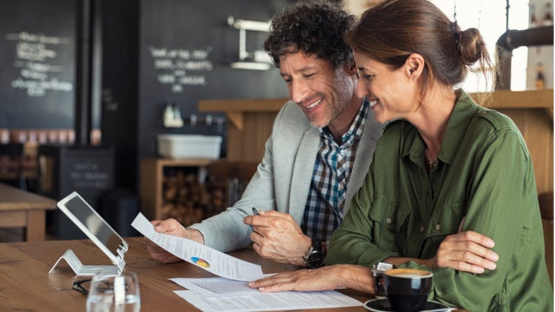 Middle-aged couple filing taxes on laptop