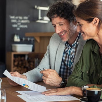 Middle-aged couple filing taxes on laptop