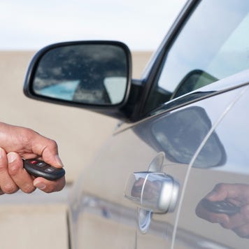 Close up of man using key fob with barcode attached to open rental car