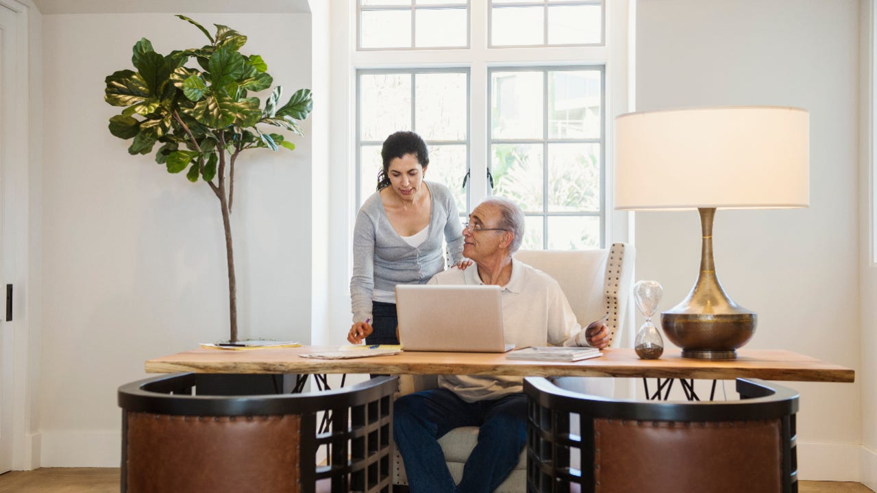 Couple using laptop in home office