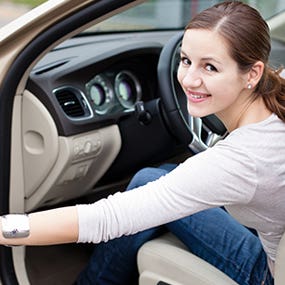 Smiling young woman closing car door © Viktor Cap - Fotolia.com