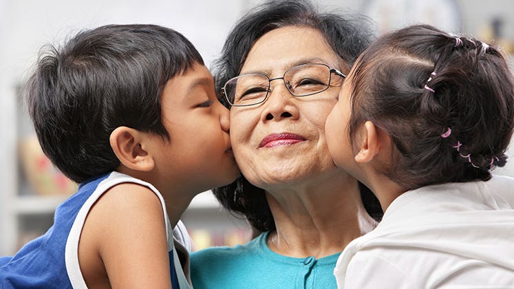 Grandmother getting kissed by grandchildren © iStock