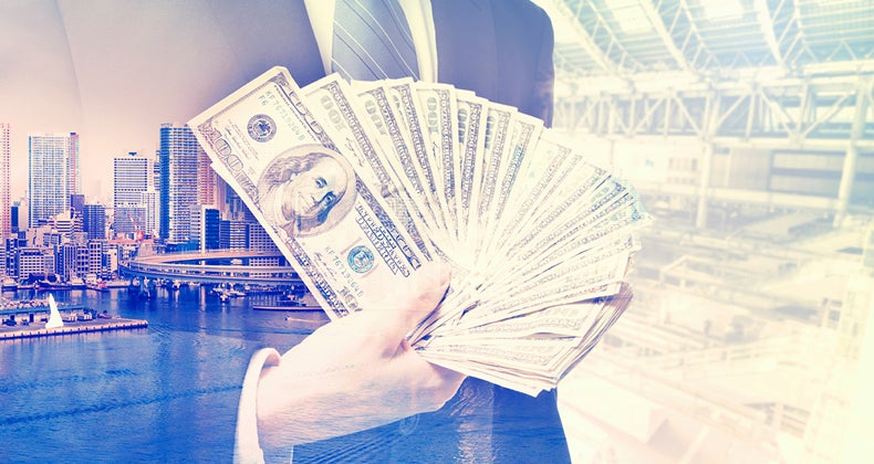 Business man holding wealth of money © iStock