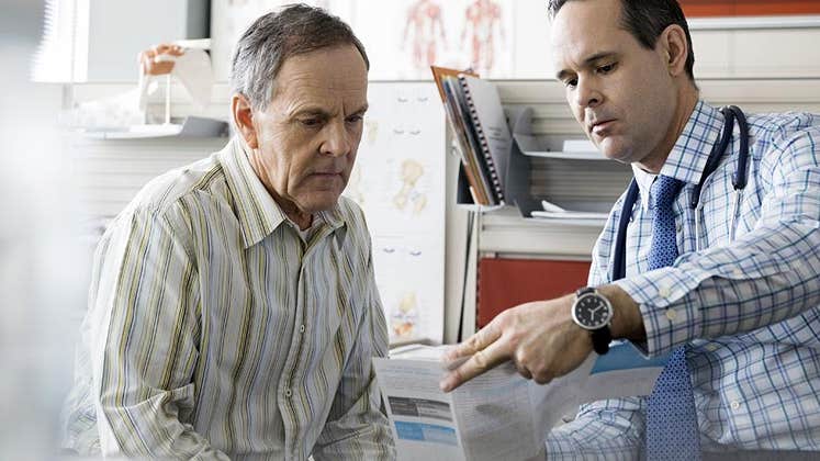 Doctor showing a pamphlet to senior patient | Hero Images/Getty Images