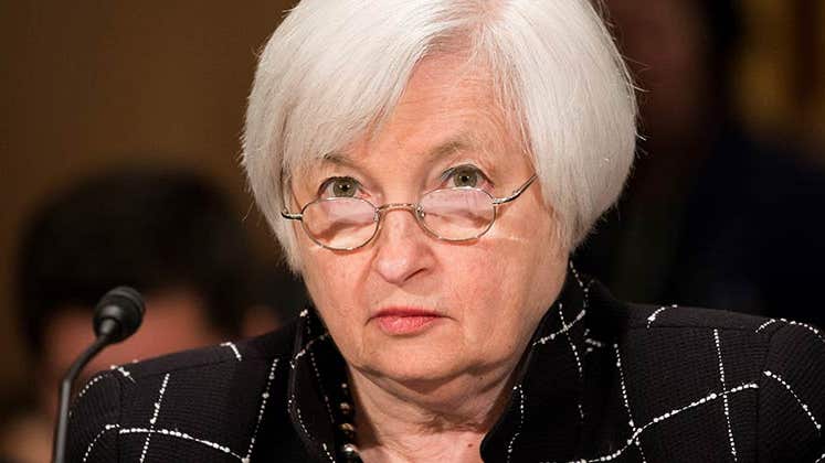 Janet Yellen looking up over her glasses | Anadolu Agency/Getty Images