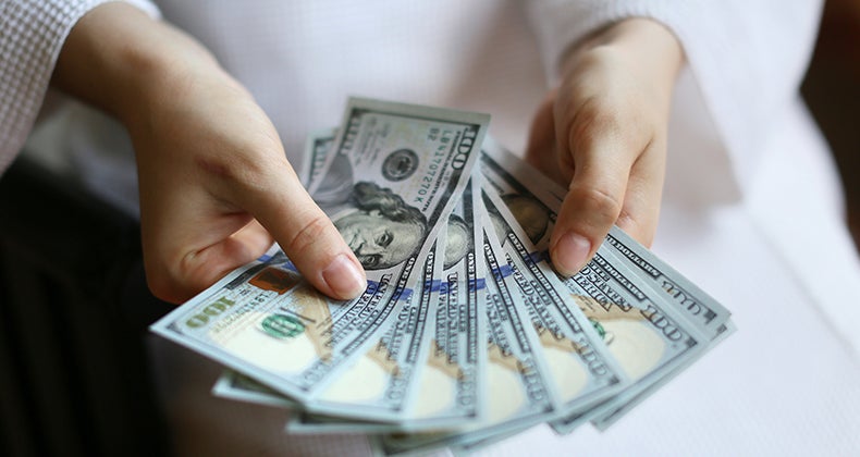 Woman's hands holding money © PavelIvanov/Shutterstock.com
