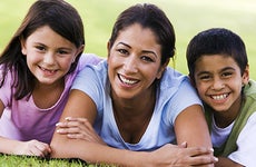 Mother and children smiling on grass © Monkey Business Images/Shutterstock.com