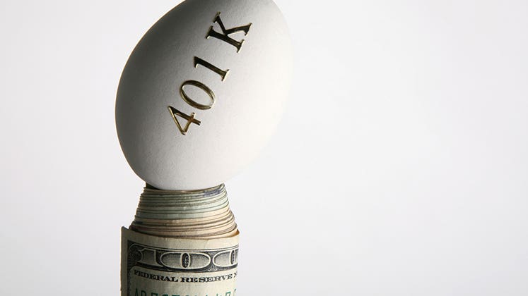 401(k) egg balanced on roll of money © iStock