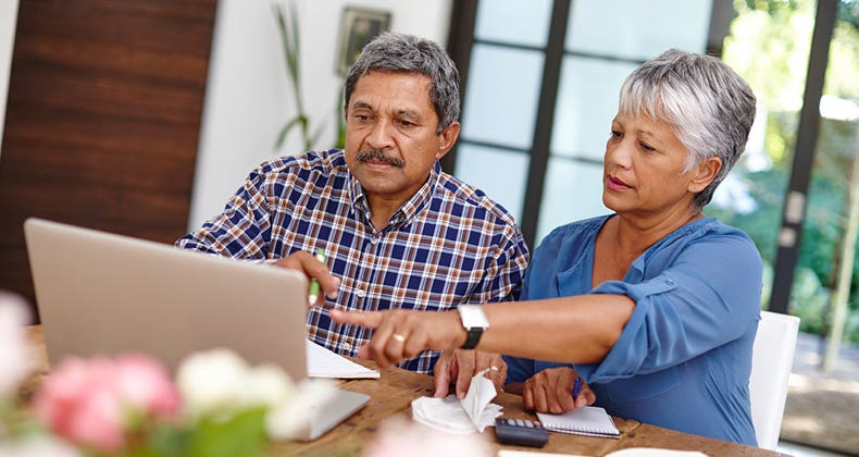 Seniors working on budget in the kitchen © iStock