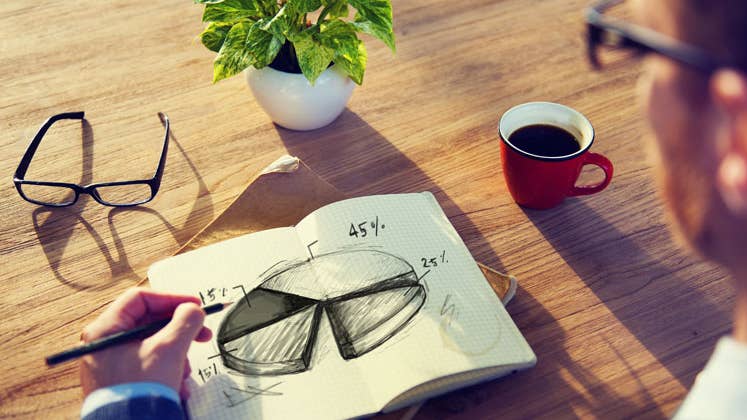 Man with a notebook drawing a pie chart © Rawpixel/Shutterstock.com