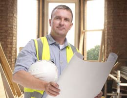 Contractor holding hard hat and blueprint