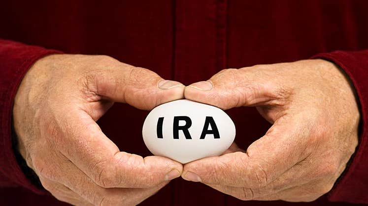 Man in red shirt holding IRA egg © Bryan Sikora/Shutterstock.com