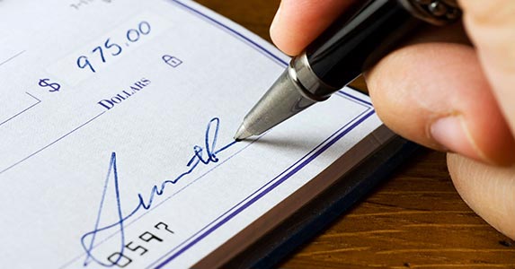 Signing someone else's name on a check | bluestocking/E+/Getty Images