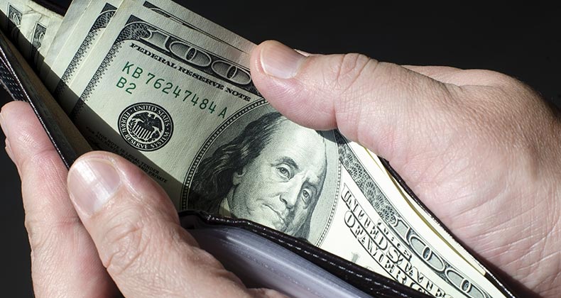 Man holding open wallet with one-hundred dollar bills © ktsdesign/Shutterstock.com