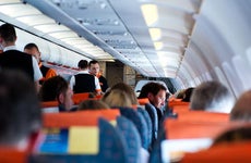 Passengers aboard flight beverage service © pcruciatti/Shutterstock.com
