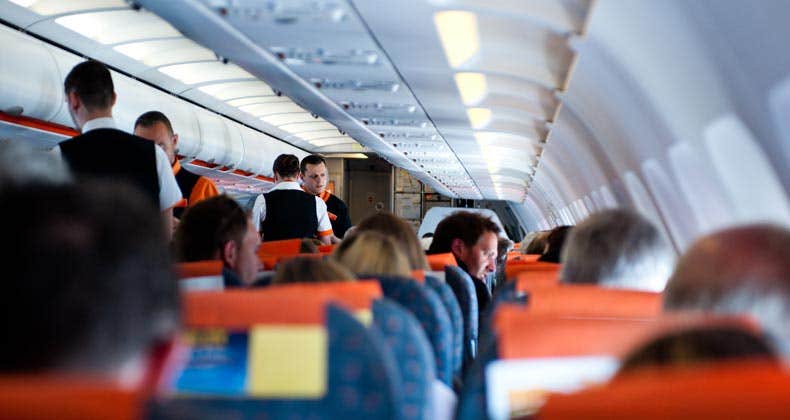 Passengers aboard flight beverage service © pcruciatti/Shutterstock.com