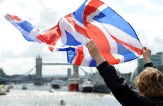 Woman holding UK flag in the air | AnadoluAgency/Getty Images