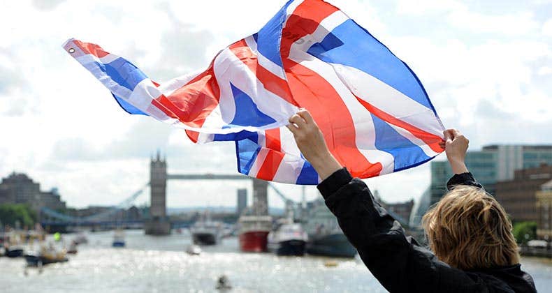 Woman holding UK flag in the air | AnadoluAgency/Getty Images