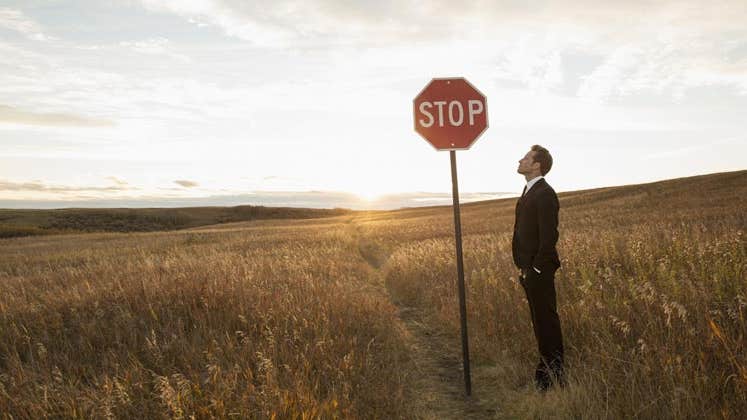 Man looking up at a stop sign | HeroImages/Getty Images
