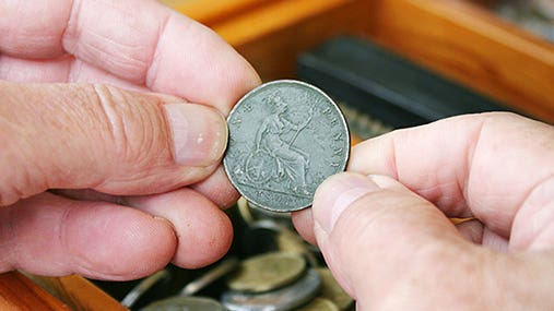 Man holding old 1901 British penny © Sue McDonald/Shutterstock.com