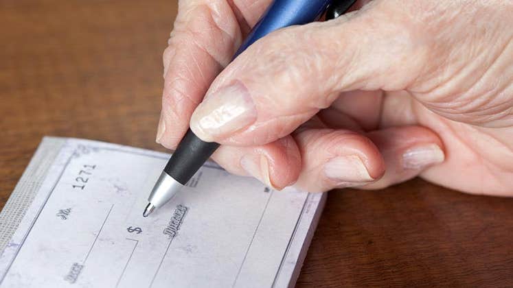 Senior writing check © iStock