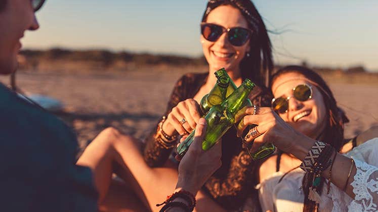 Friends clinking beer bottles together © Anchiy/Shutterstock.com