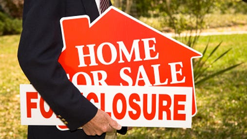 Foreclosure sign under arm © iStockPhoto.com