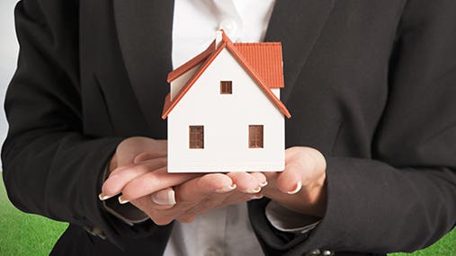 Real estate agent holding house in hands © alphaspirit/Shutterstock.com