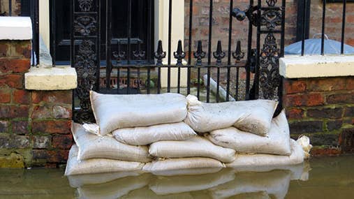 Flooded home entrance blocked by sandbags © ronfromyork/Shutterstock.com