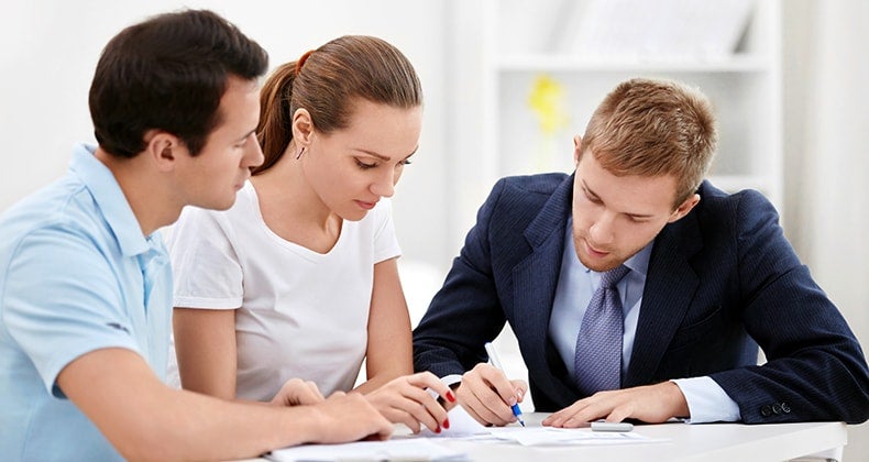 Consultant with young couple reviewing documents © Deklofenak/Shutterstock.com