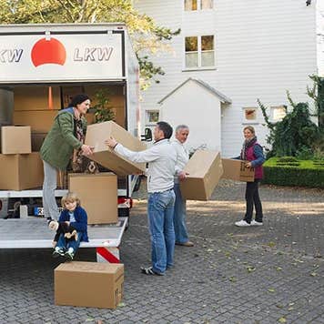 Group taking boxes off of the moving truck | Westend61/Getty Images