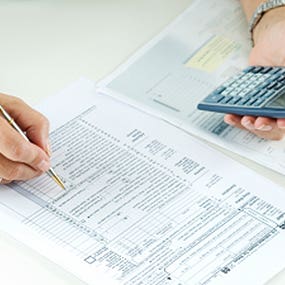 Woman doing taxes with calculator